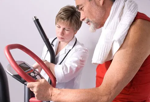 A doctor checks the results of a senior man exercising on a treadmill.