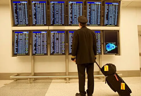 Photo of an airplane pilot checking flight departure times.