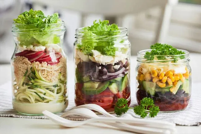 Glass mason jars are simple ways to tote single-serving salads to work or school for an easy, nutritious meal.