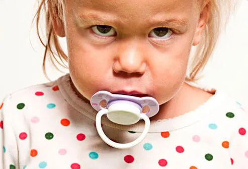 A child upset with a pacifier.