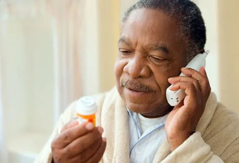 A man speaks with his doctor on the phone about his medication.