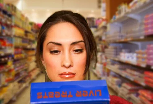 Photo of woman reading pet food ingredients.