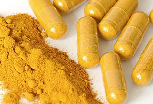 Yellow turmeric powder inside clear pills.