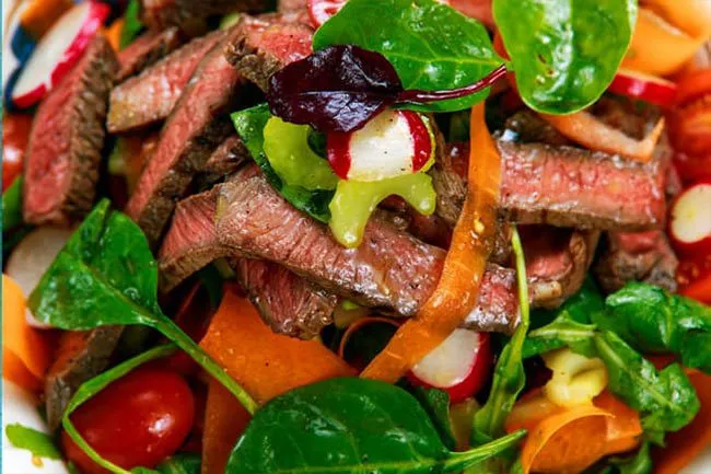 Steak salad with lots of veggies and a light dressing is a healthy meal choice. 