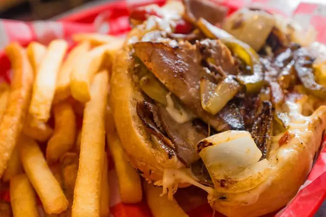 Philly cheese steak is high in saturated fat and calories and you'll get extra doses of carbs and sugar if you eat it with fries and a soda. 