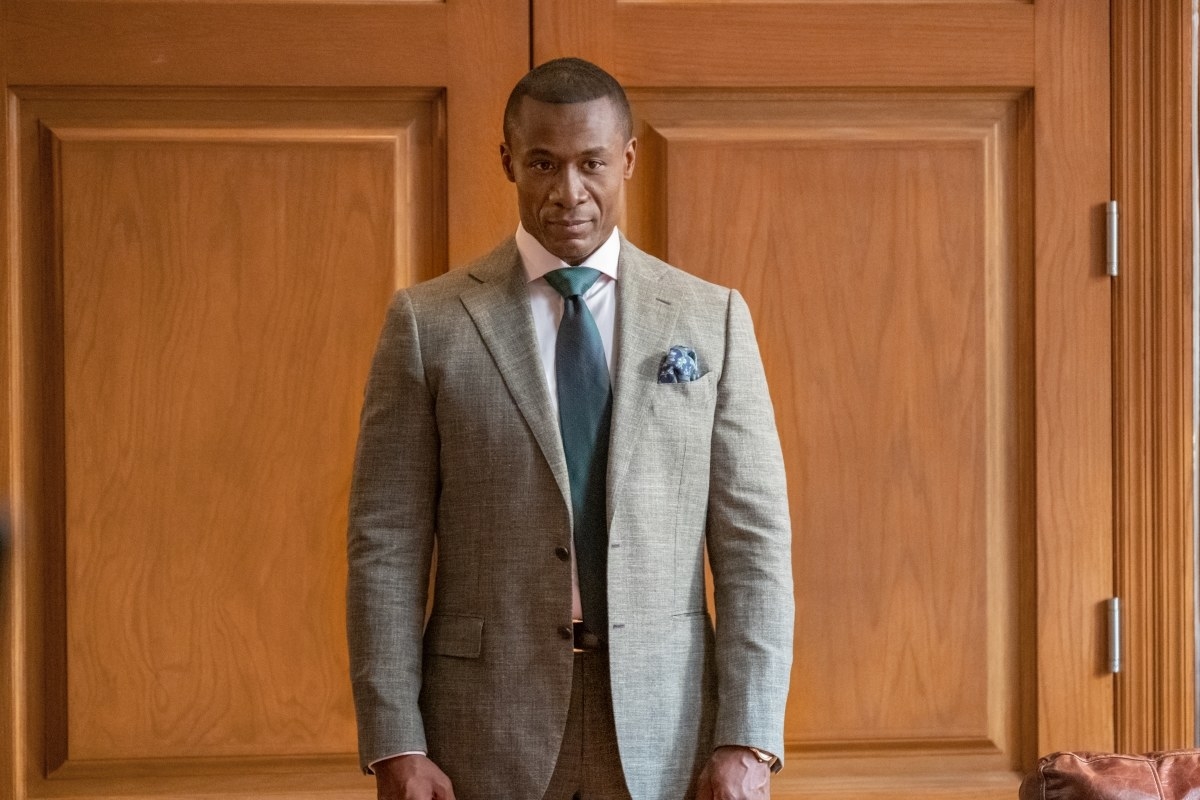 Sean Blakemore looks mischievous with arms by his side, standing in front of double doors