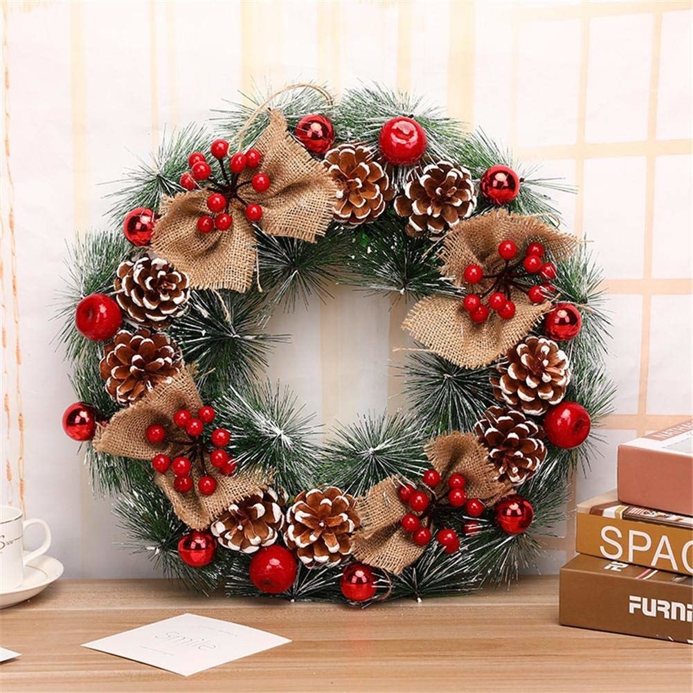 A stunning wreath with white dusted fake pine, burlap bows, holly berries, cherries and pine cone flowers.