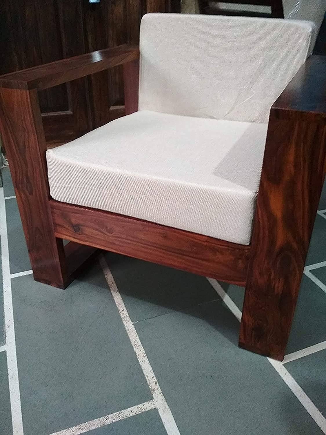 A wooden chair on a grey and white carpet