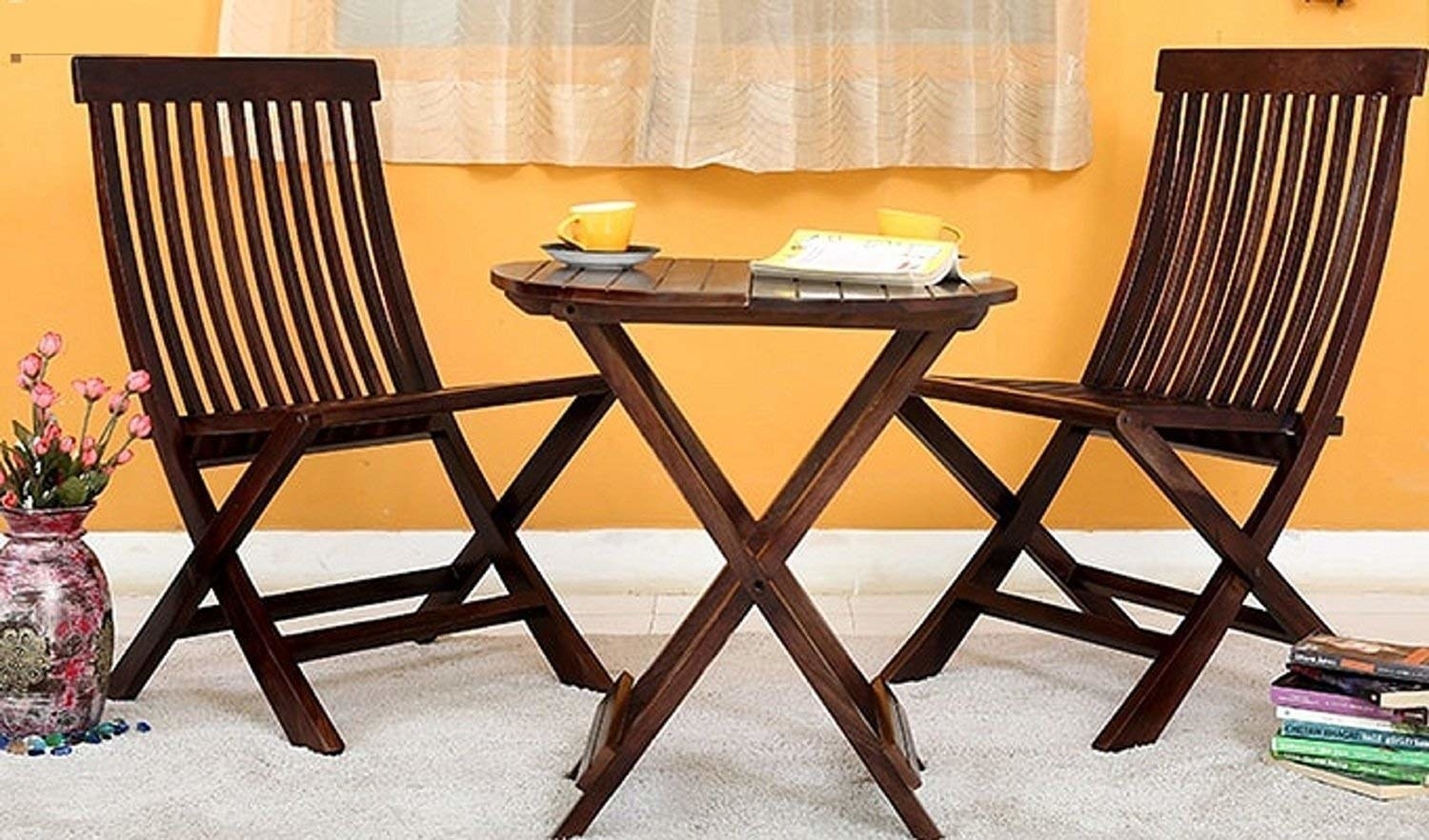 Two chairs with a table and a book and a coffee cup on it