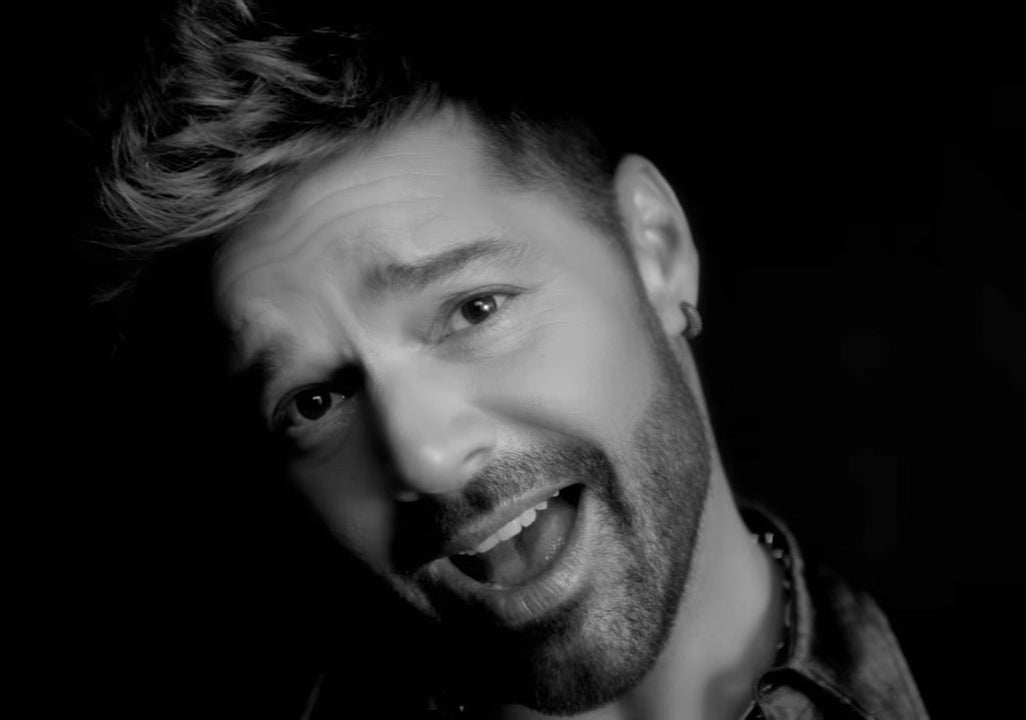 Black-and-white headshot of Ricky singing