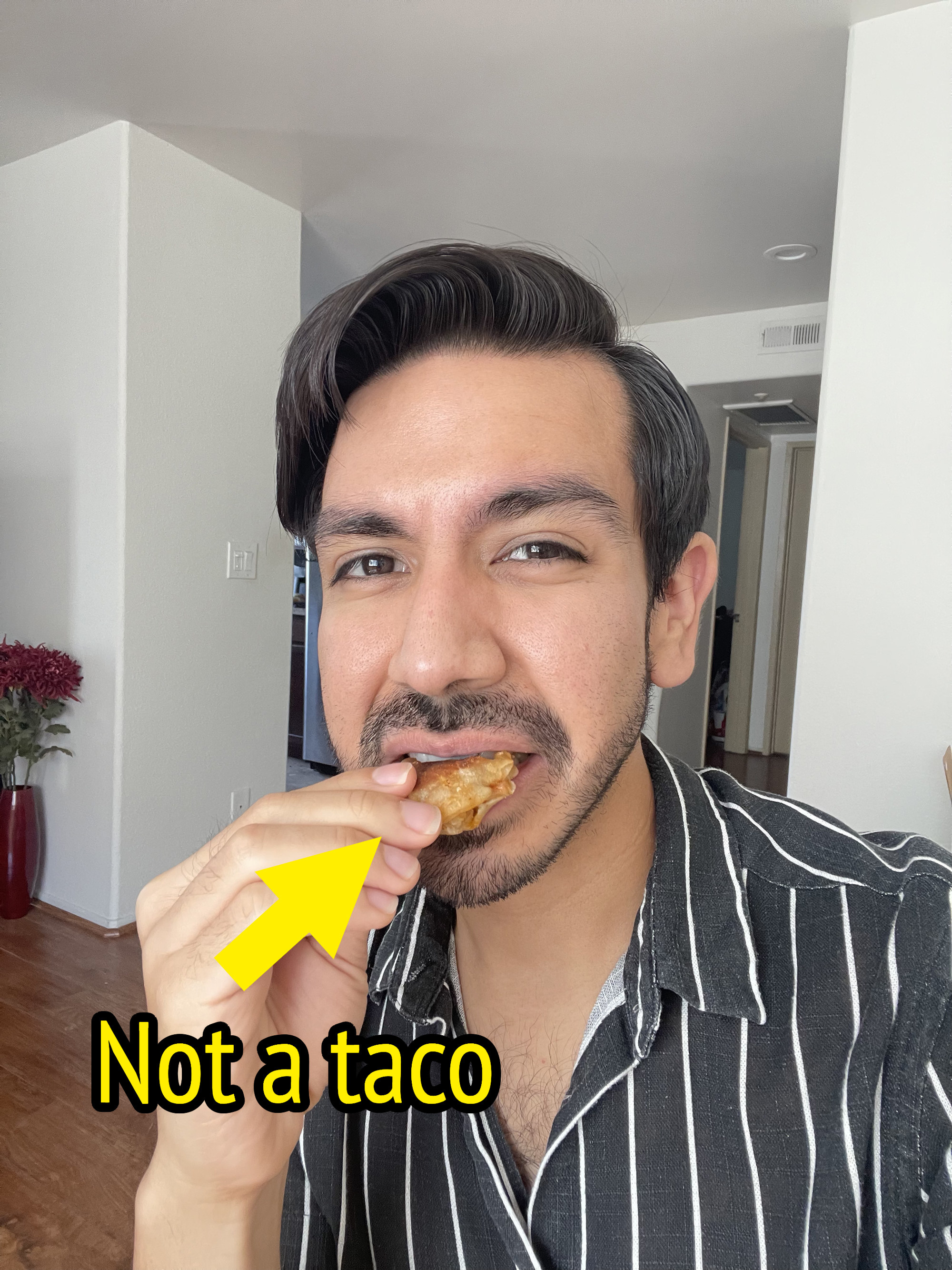 The author eating an empanada with the words &quot;not a taco&quot;