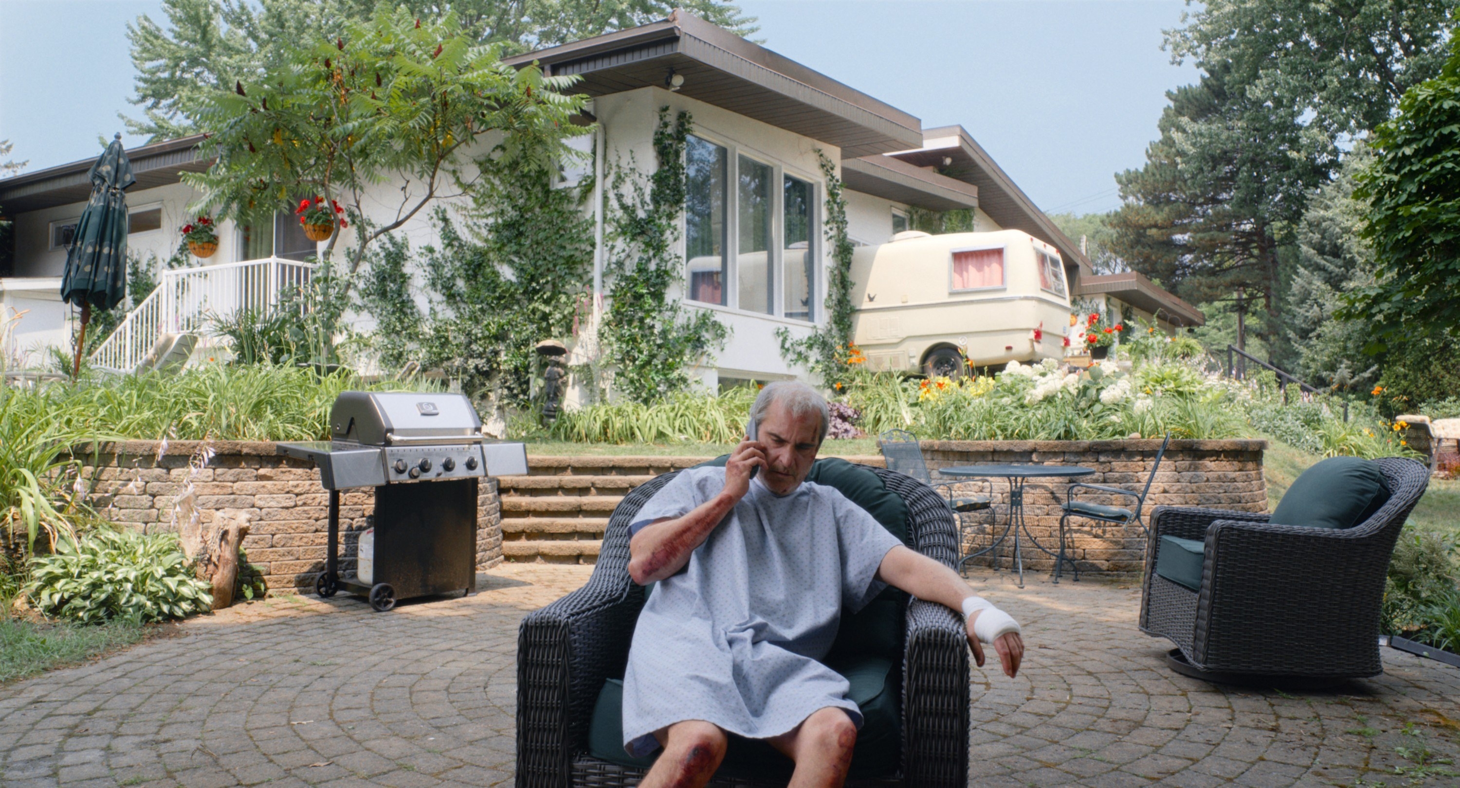 Beau sitting outside in a hospital gown on the phone