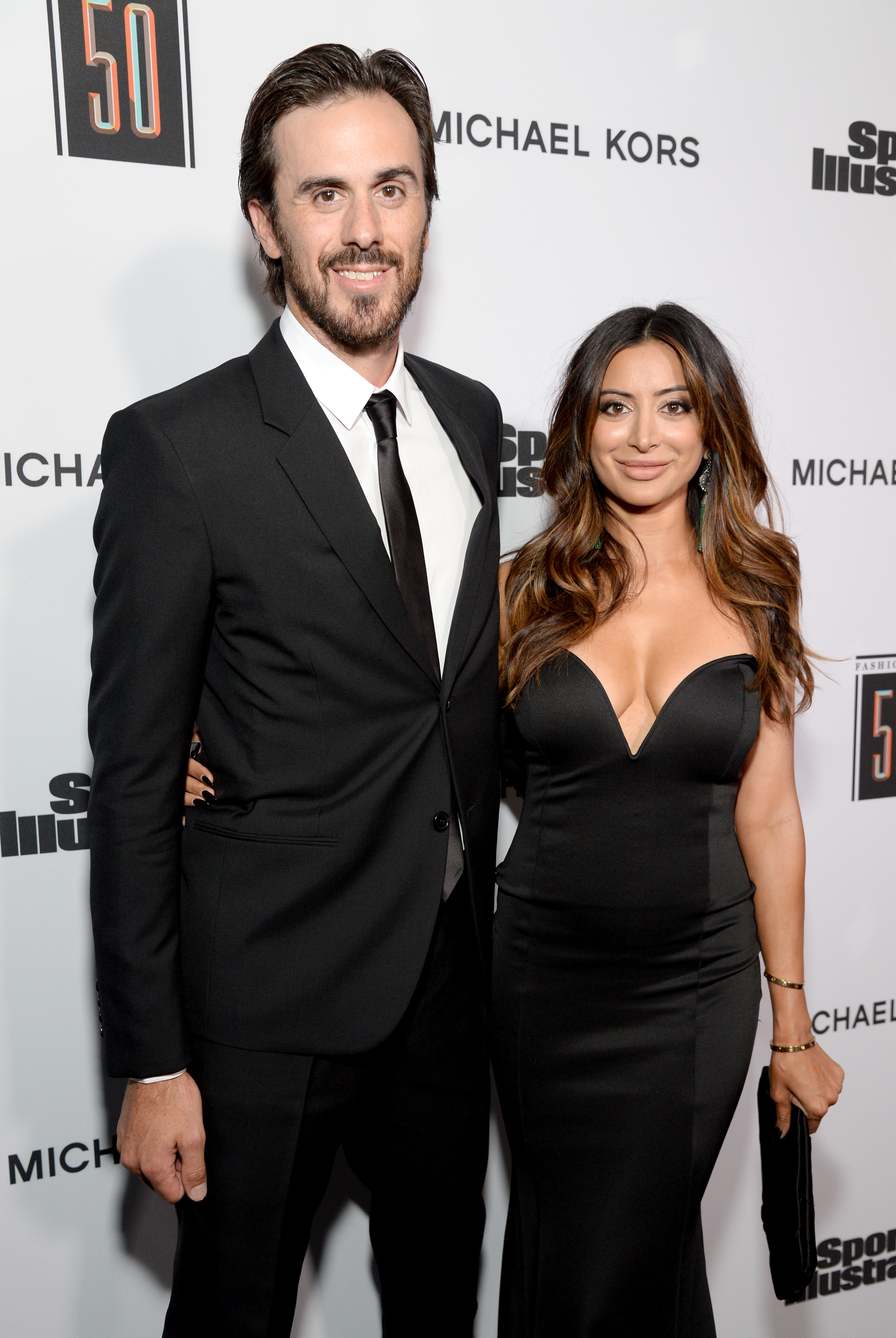 Two people posing together, both dressed in elegant black attire