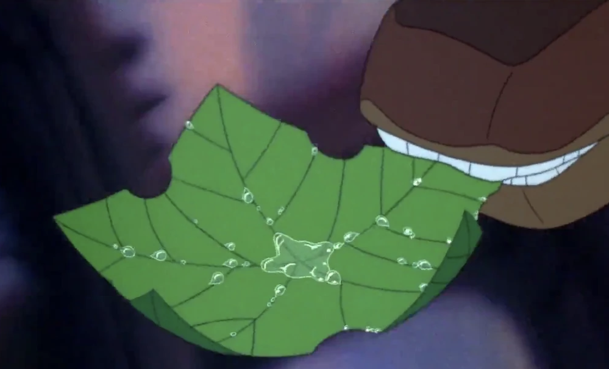 Animated dinosaur eats a green leaf covered in water droplets. Close-up view