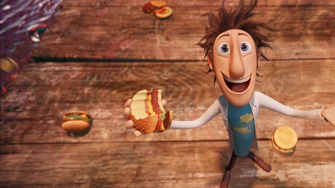 Flint Lockwood from &quot;Cloudy with a Chance of Meatballs&quot; excitedly holds a cheeseburger while more food items fall from the sky around him