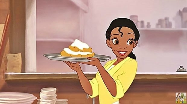 Tiana from The Princess and the Frog cheerfully holds a plate of powdered sugar beignets in a kitchen setting