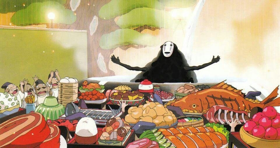 No-Face from Spirited Away sits at a table piled high with food, arms outstretched. Various animated characters on either side are cheering and eating