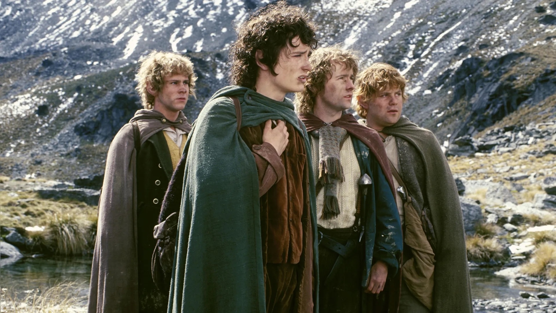 Actors dressed as hobbits in &#x27;The Lord of the Rings&#x27;: Sam, Frodo, Merry, and Pippin stand together in a mountainous landscape