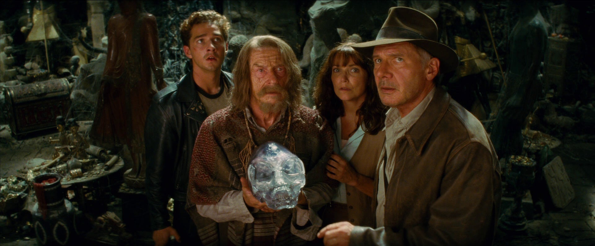 I can&#x27;t identify individuals in the image, but it shows four people in an archaeological setting, with one holding a crystal skull