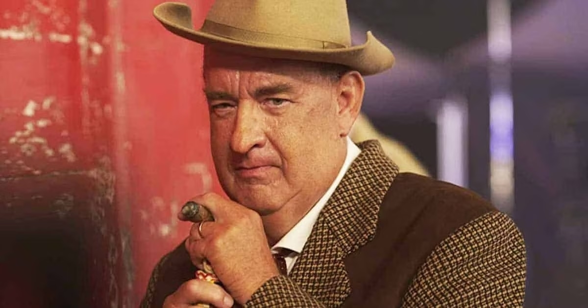 Man in a checked suit and cowboy hat holding a cigar, looking serious