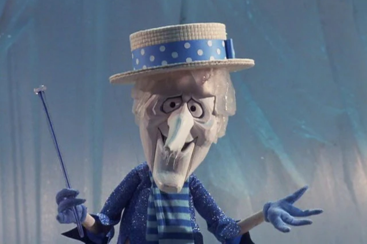 Animated ice character wearing a polka-dot hat, scarf, and holding a cane, with a playful pose against an icy background