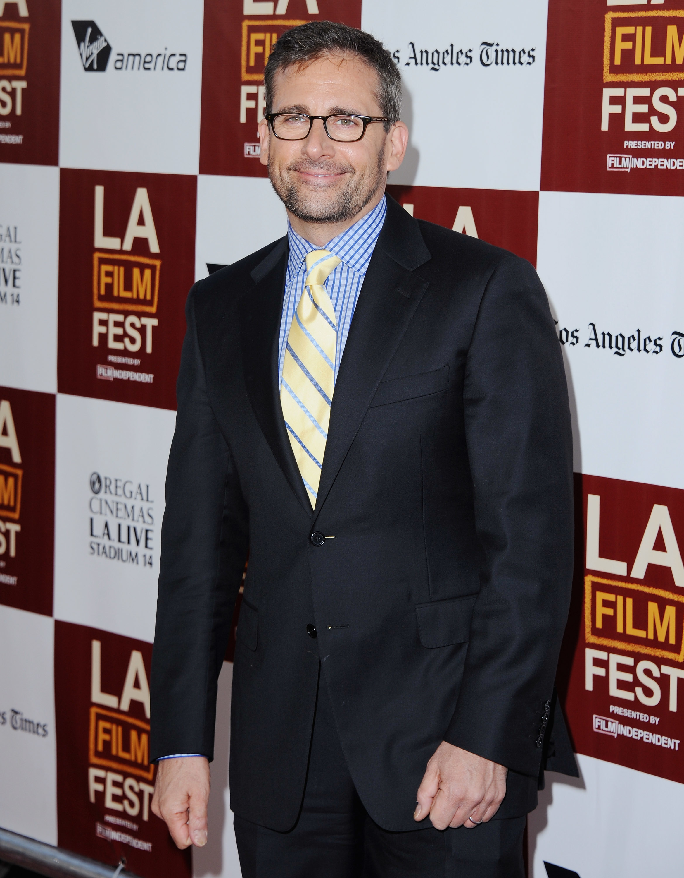 Man in a suit with a striped tie poses at the LA Film Fest red carpet