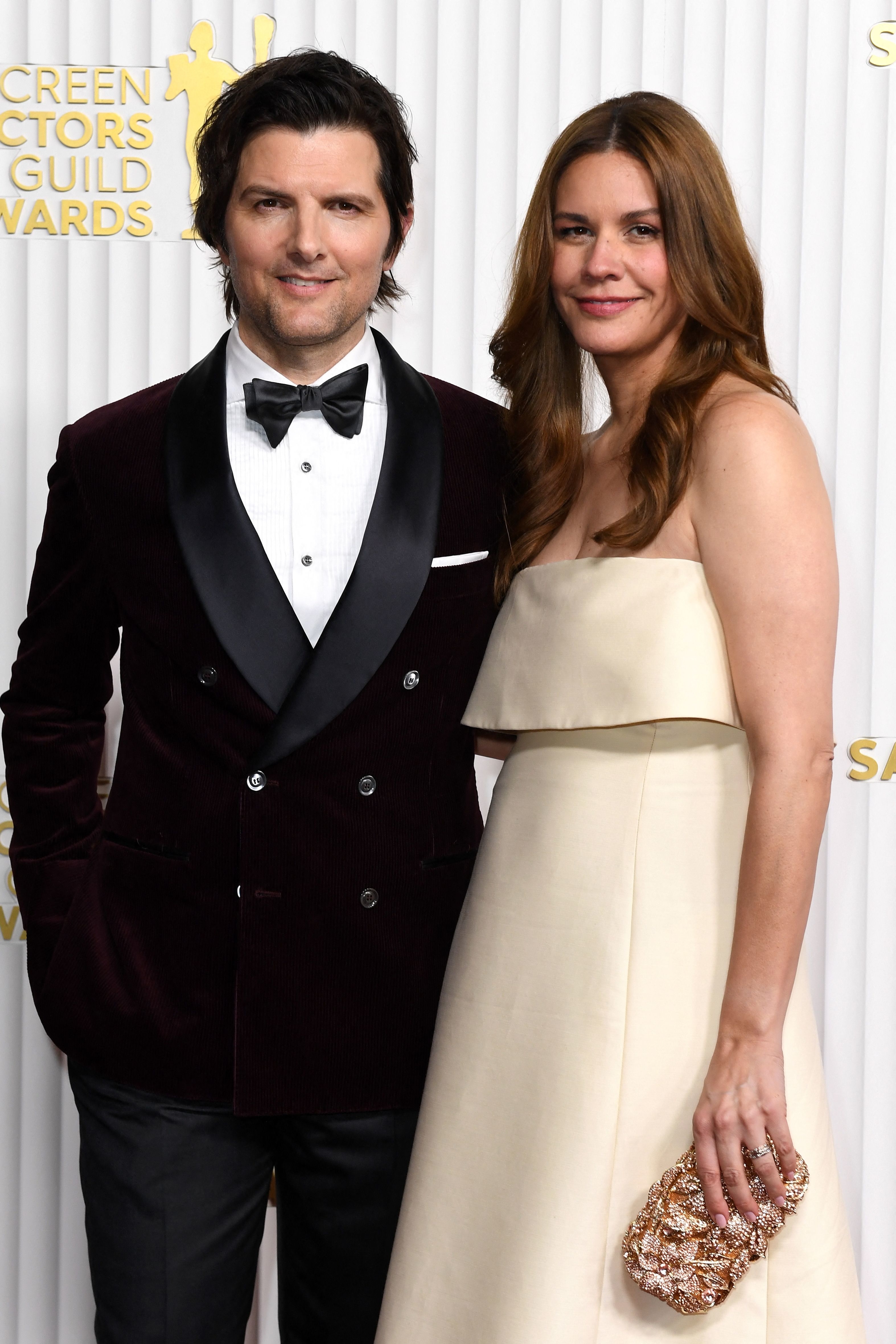 Man in tuxedo and woman in strapless gown pose on Screen Actors Guild Awards red carpet