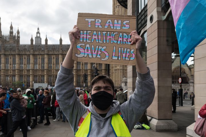 Campaigner carries sign which reads: "Trans healthcare saves lives"