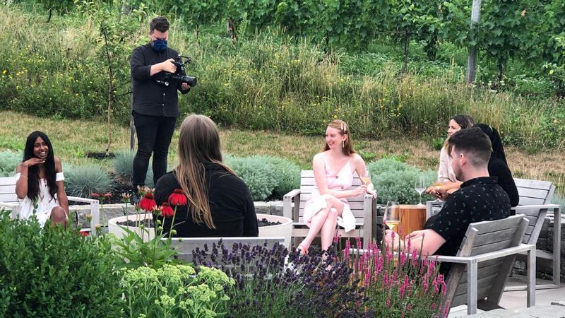 A videographer records people sitting at the Benjamin Bridge winery