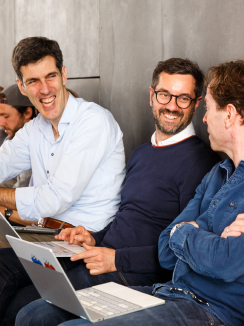 3 men smiling and discussing