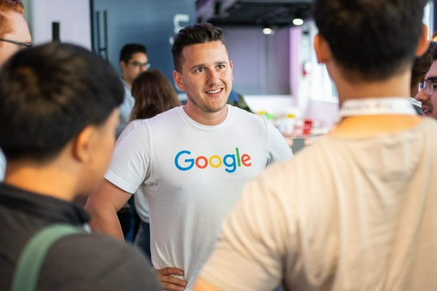 Man wearing a Google tshirt talking to a group of people.