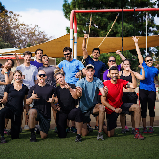 A crowd of people wearing athletic apparel smile and pose for a group picture