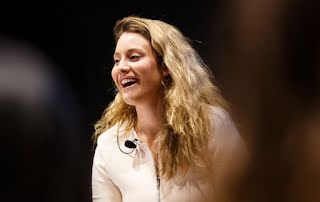 A smiling woman wearing mic - mobile