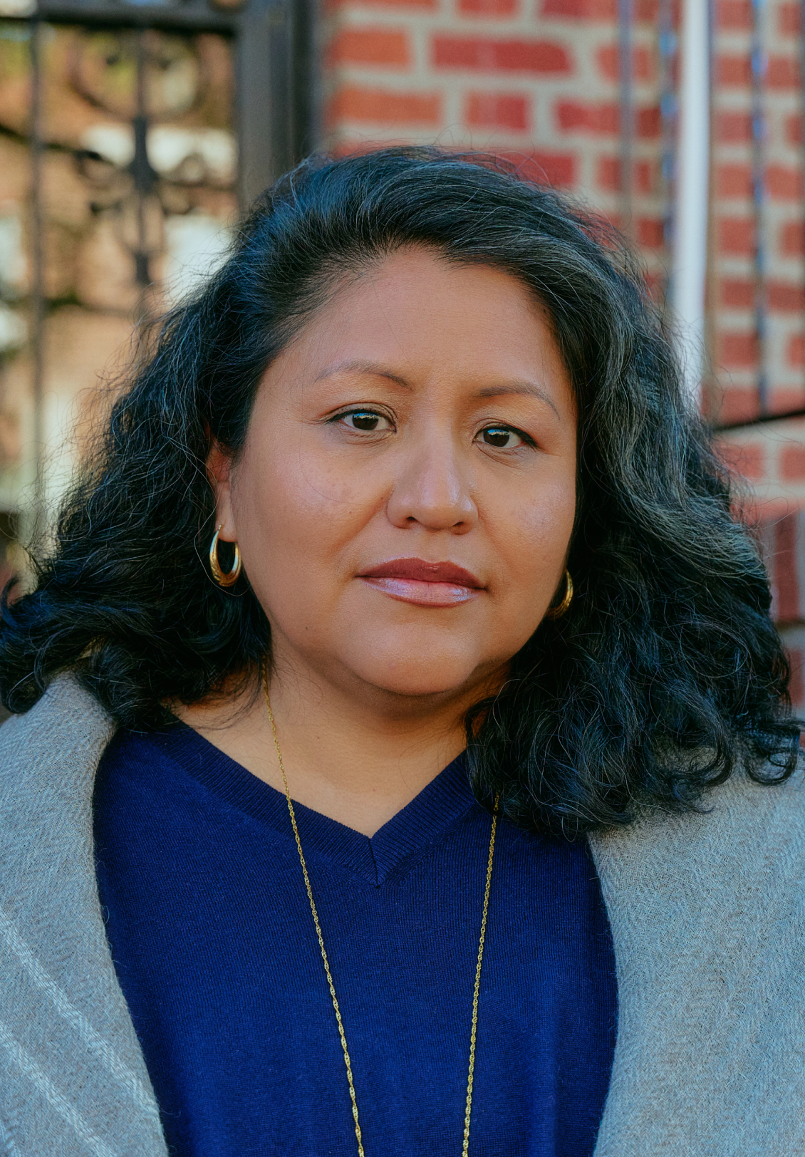 A middle-aged Latina woman wearing hoop earrings.