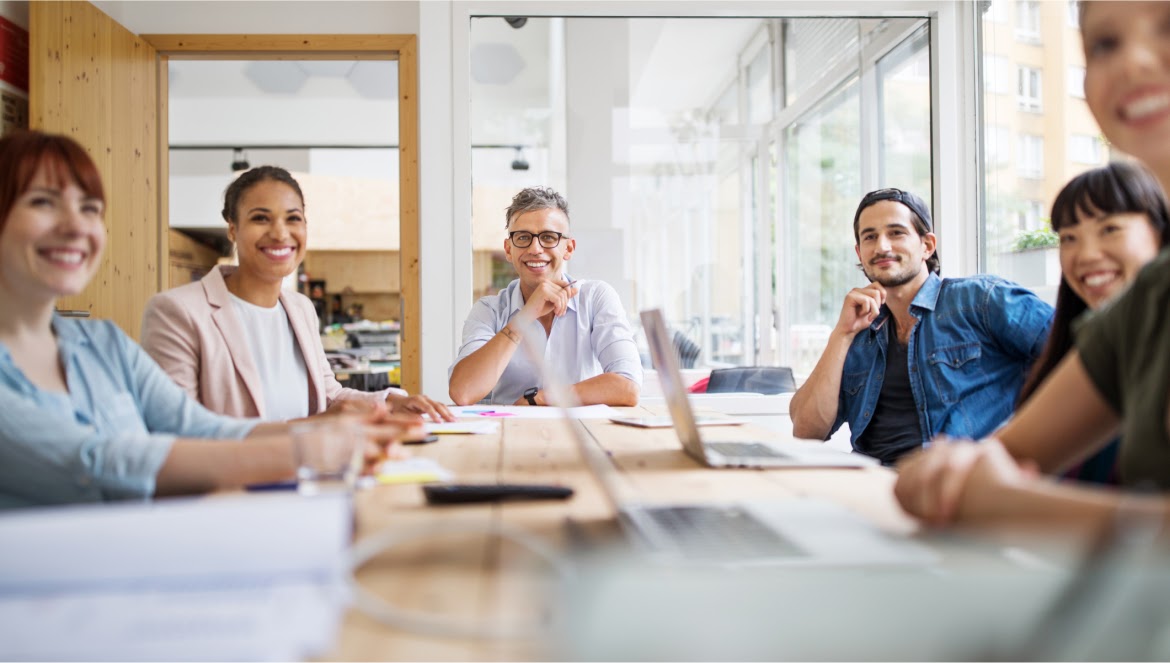 Coworkers sitting around a table in an office setting. 