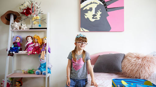 Liberty’s bedroom with a painting of the Statue of Liberty behind her.