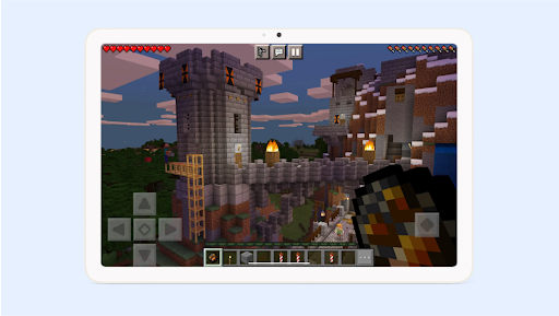 A tablet screen displaying a cobblestone castle from Minecraft.