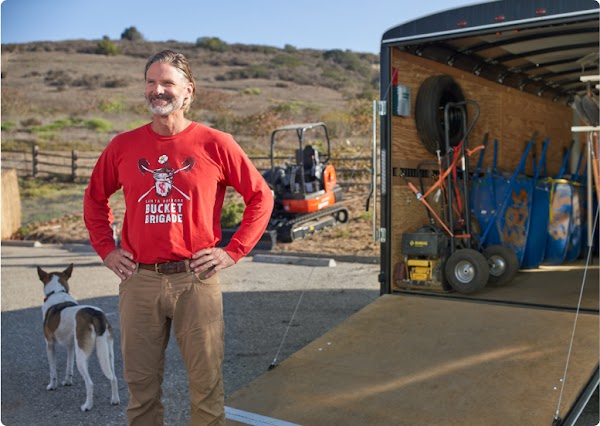 Abe in front of supplies regularly used by Bucket Brigade volunteers.