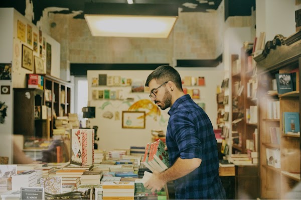 Inside the shop he lays the books out into carefully stacked piles