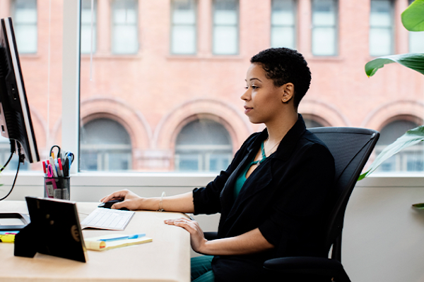 A woman working at a computer in a modern office space.