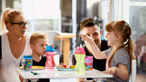 The Collins’ family sitting around a table having lunch.