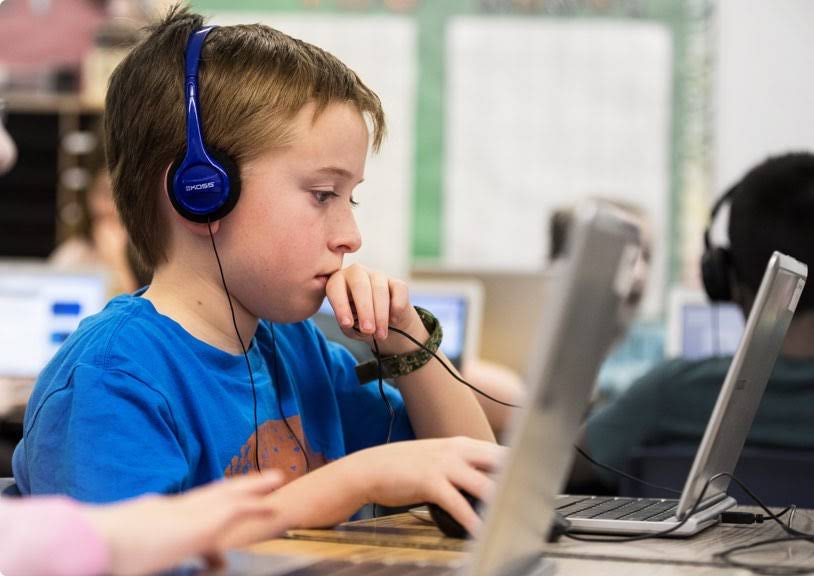 Un bambino con le cuffie utilizza un Chromebook.