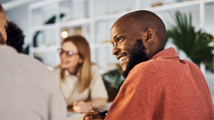 Smiling colleagues sitting together at a table. 