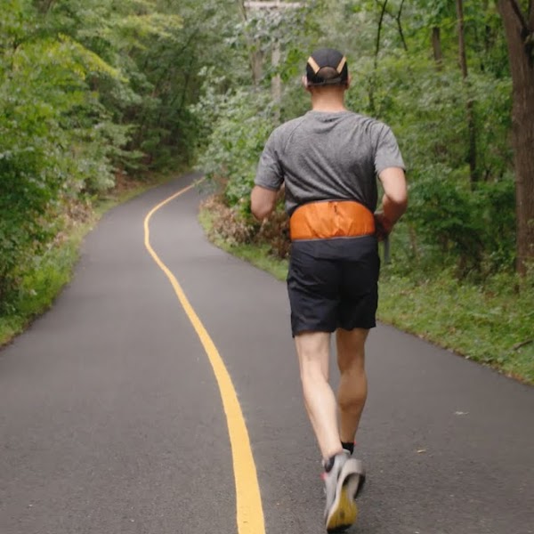 A blind man runs alone down a path