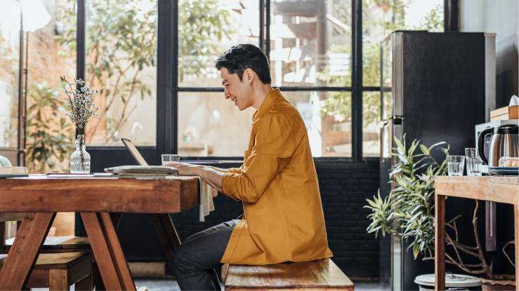 Person som sitter ved en pult og jobber på en laptop 