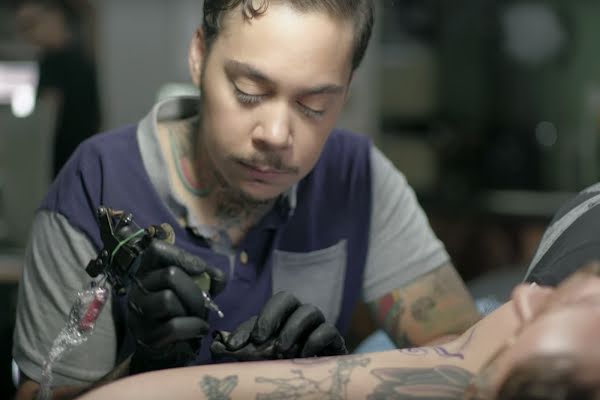 Image: Jasmine tattoos a customer.