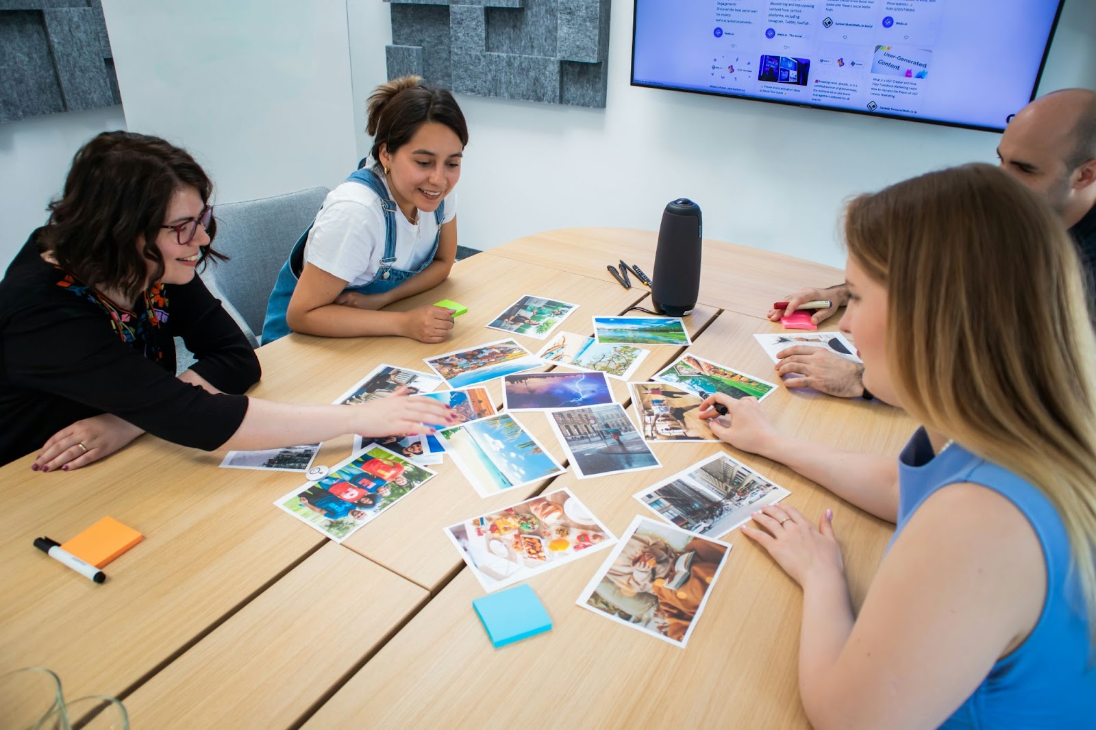 Colleagues are looking at printed photos in a meeting room