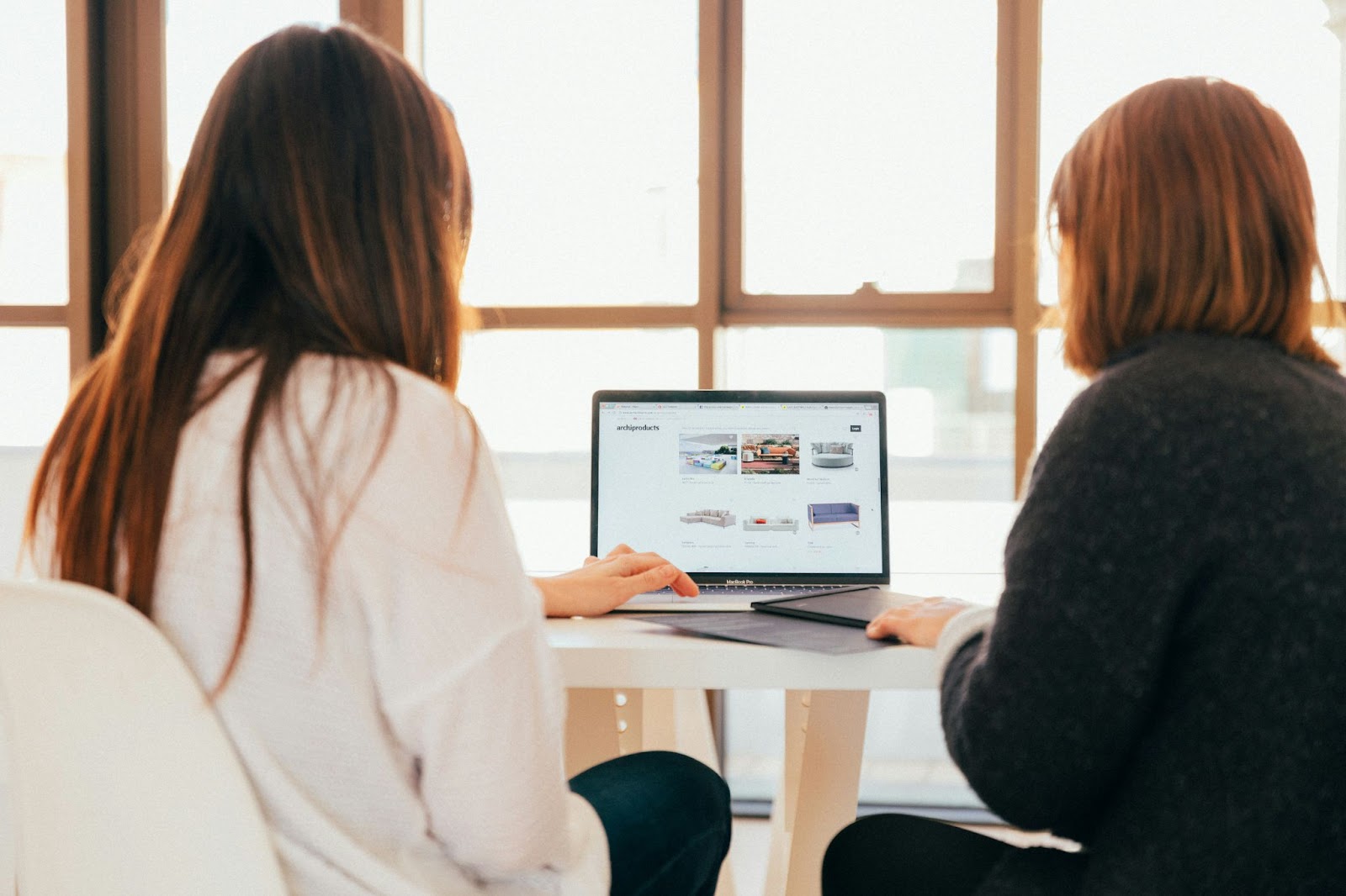 Two female colleagues working together on a laptop