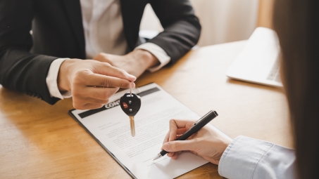 person handing car keys to new owner 