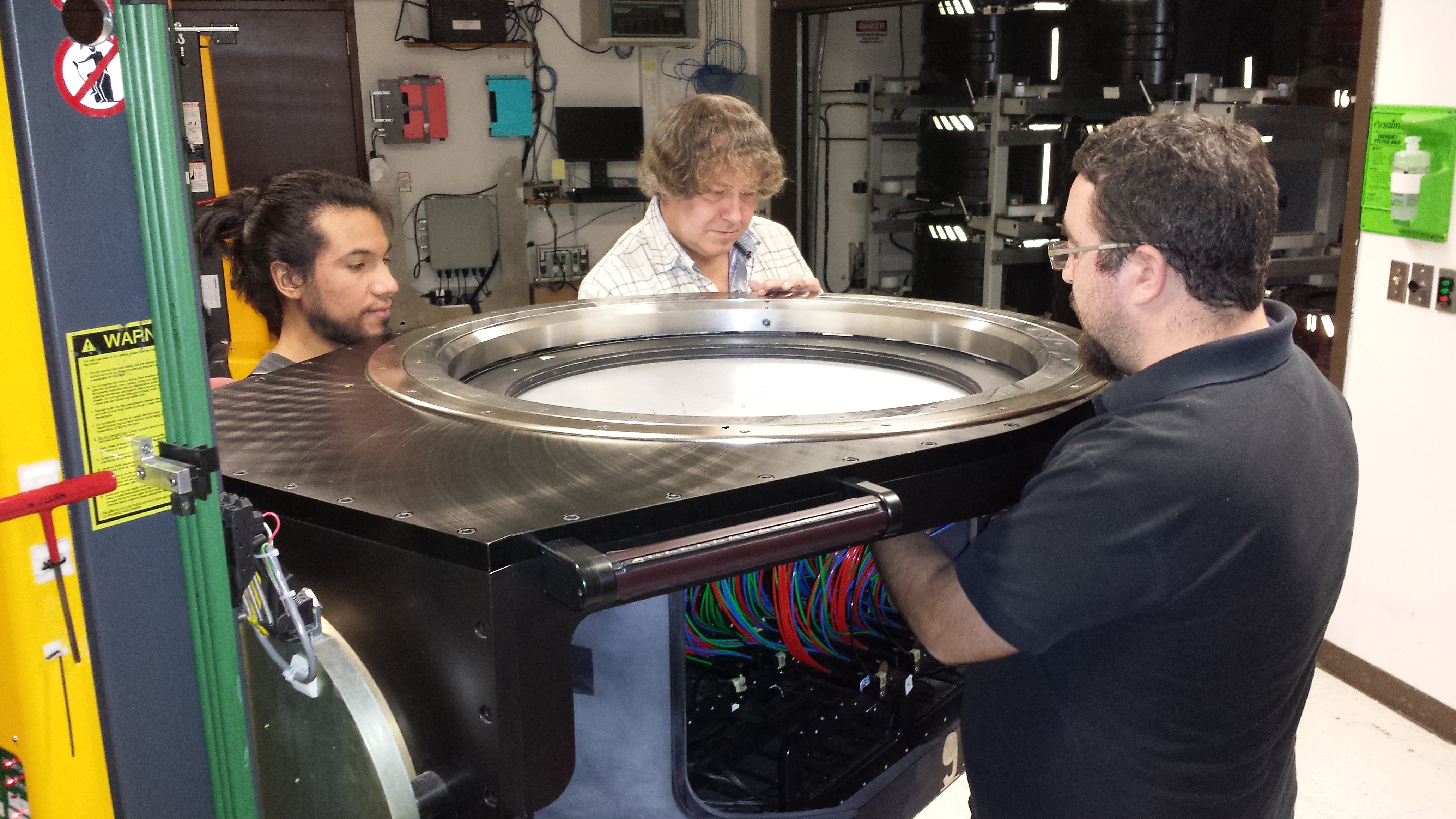 Jamie (left) Christian (center), and Andres (right), unplugging an APOGEE plate after observations. Jamie (a la izquierda), Christian (al centro), y Andrés (a la derecha), desconectando las fibras ópticas de una placa de APOGEE después de las observaciones.